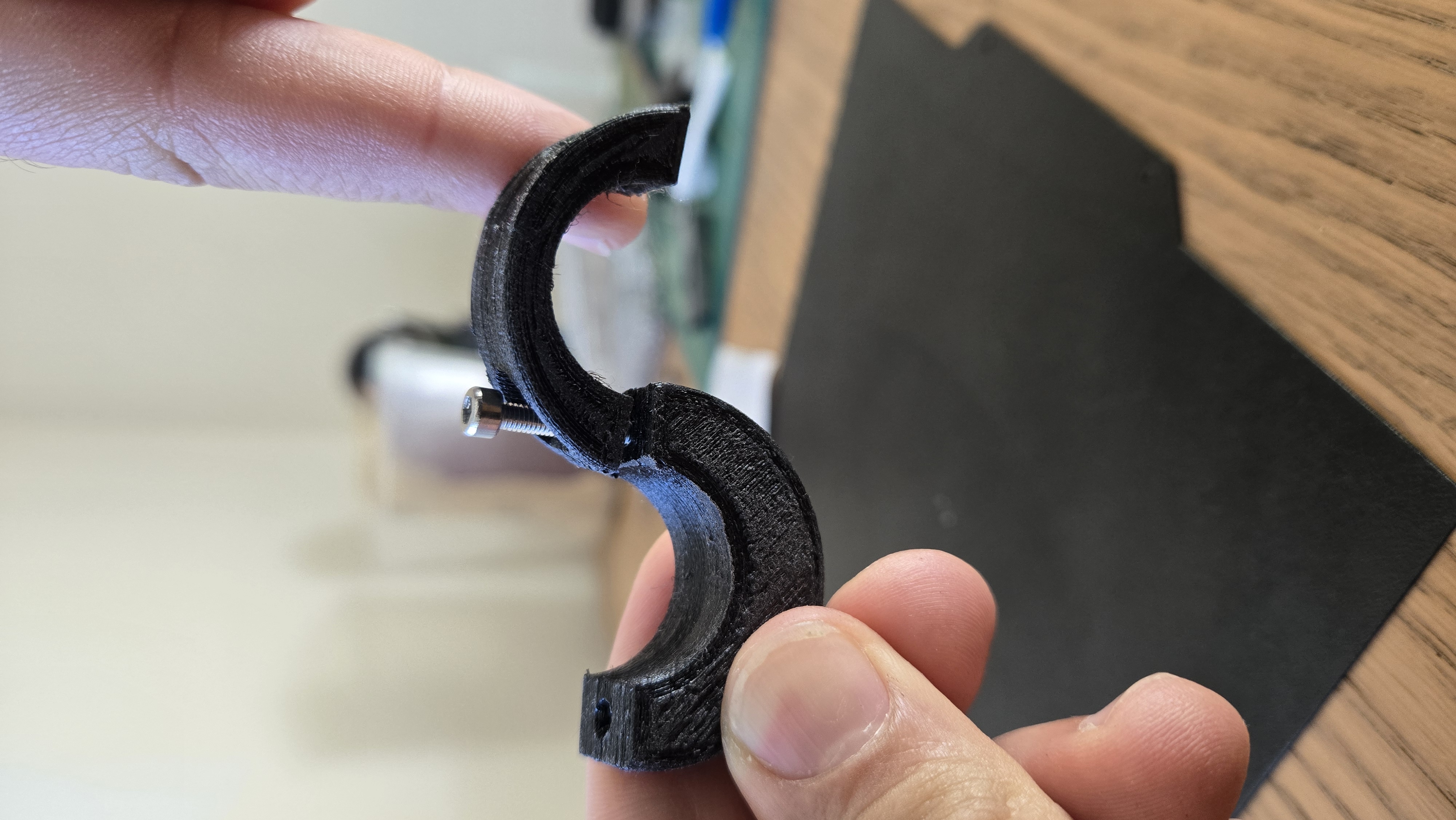 PurionClip tenu en main — les 2 demi-lunes assemblées avec vis inox